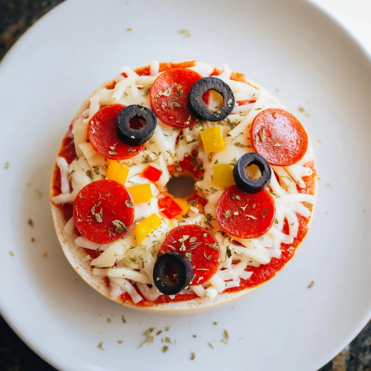Golden, bubbly mini bagel pizzas with melted cheese and crispy bagel crusts, ready to eat.