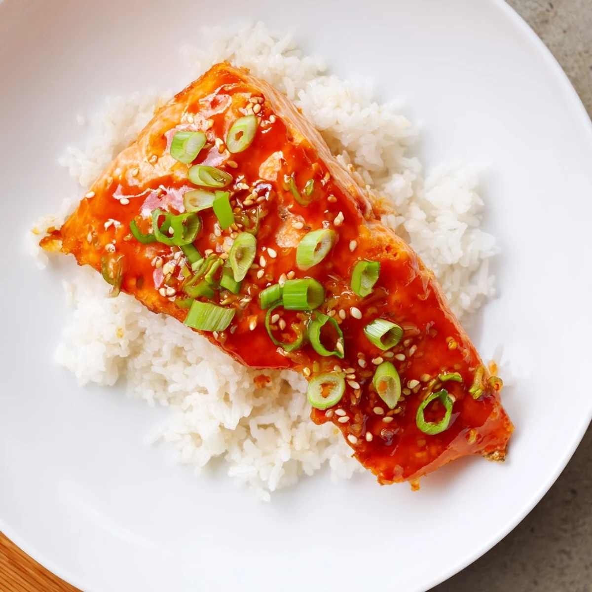 Tender Sticky Orange Salmon glistening on a bed of fluffy rice, a delicious Asian-inspired dinner.