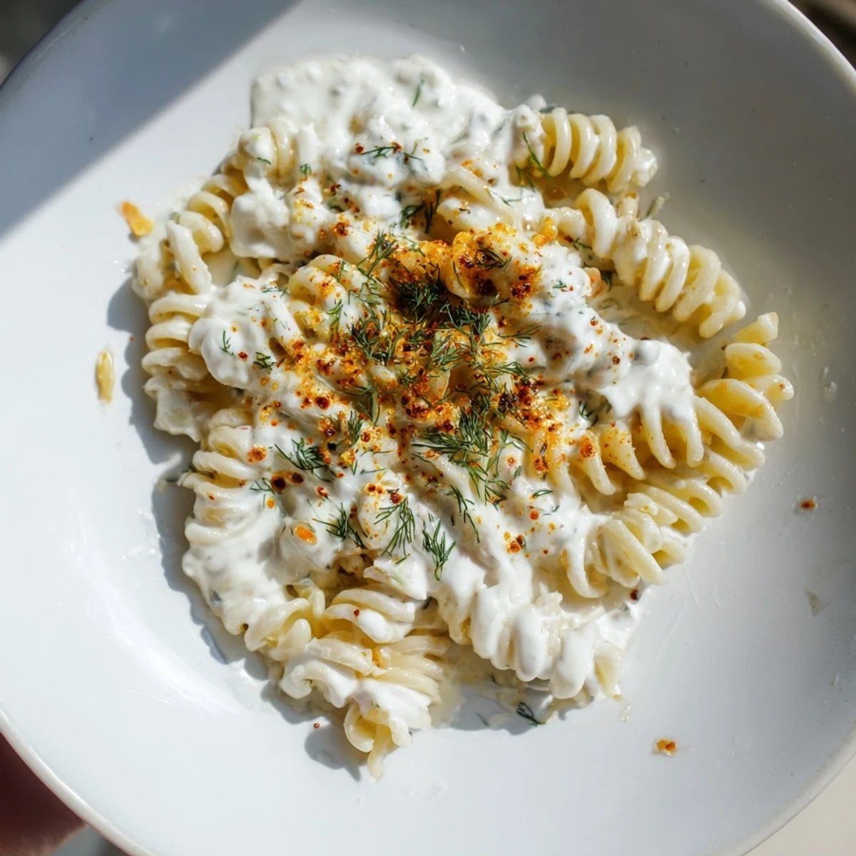 Creamy Turkish Yogurt Pasta, swirled and topped with spiced butter, ready for a delicious dinner.
