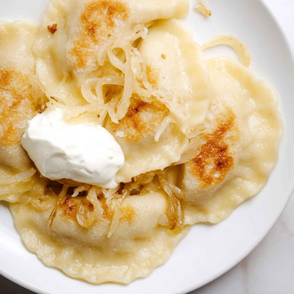 Golden Polish pierogi dumplings are filled with creamy potato and cheese, perfectly pan-fried.