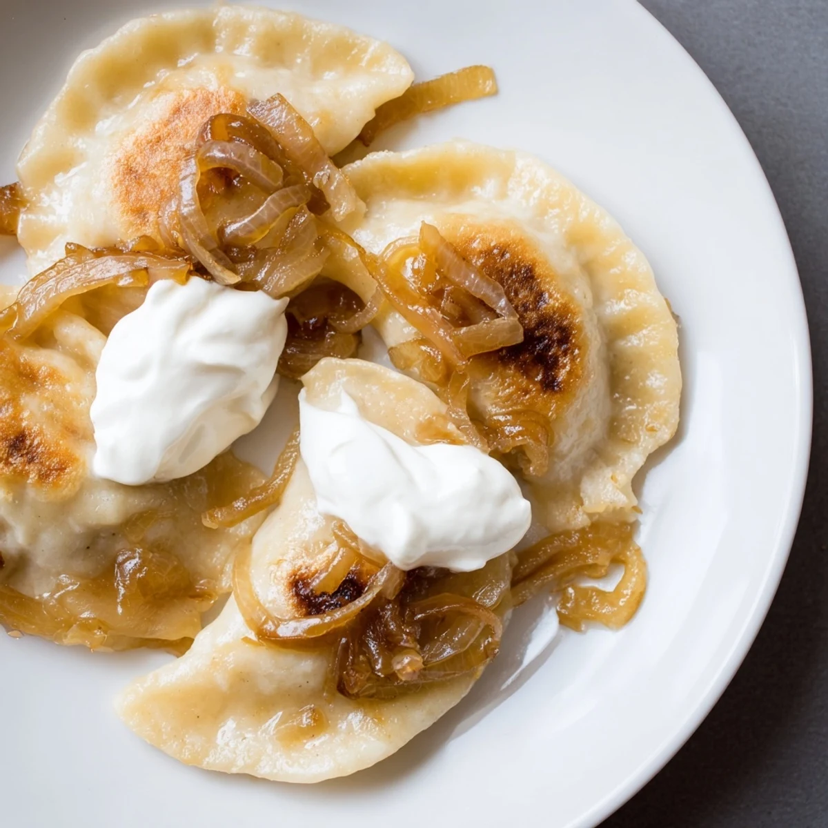 A close-up of delicious, browned Polish pierogi; these are brimming with potato and cheese filling.