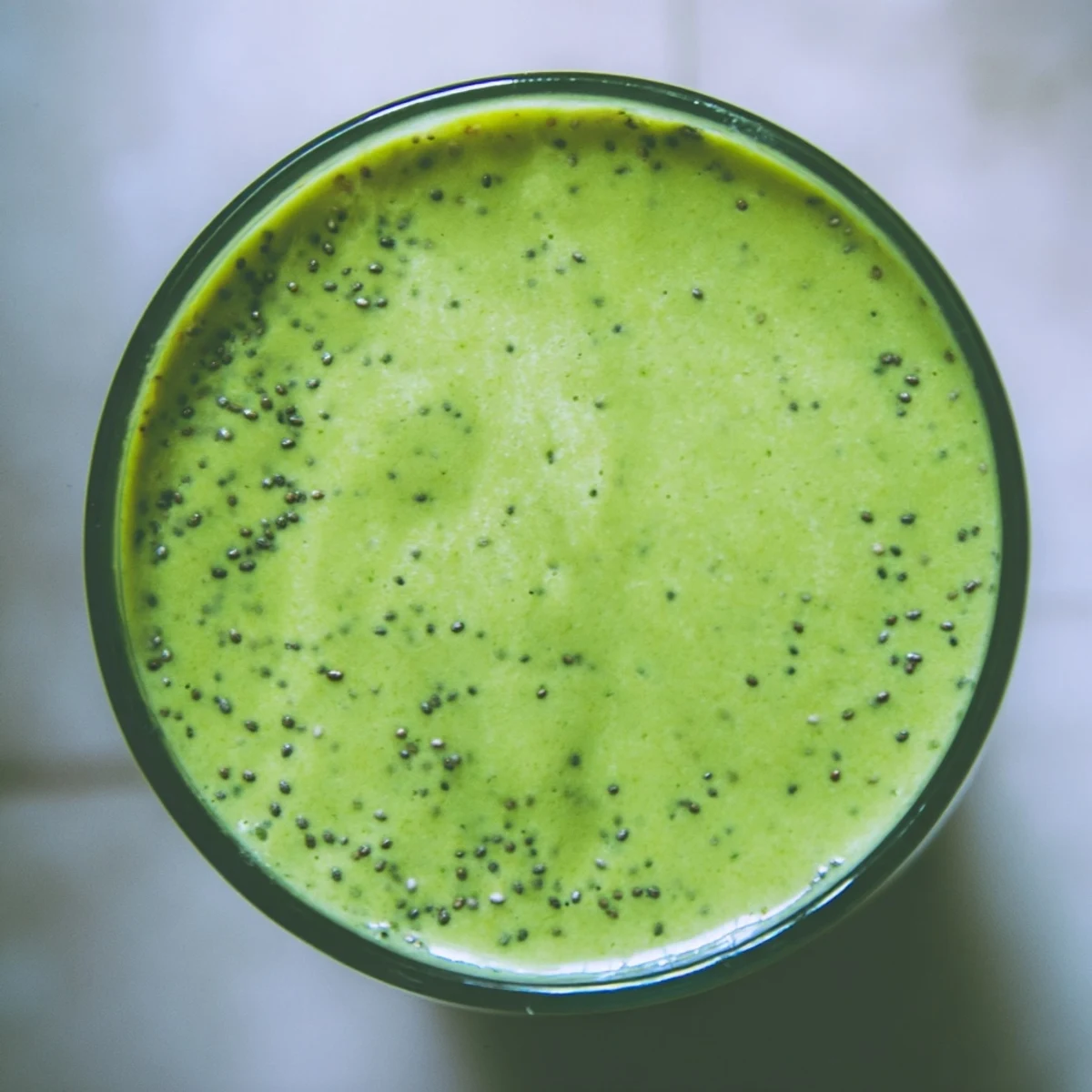 Thick, creamy Spinach-Hidden Smoothie in a tall glass, blending tropical pineapple and mango flavors with hidden spinach for a nutritious breakfast.
