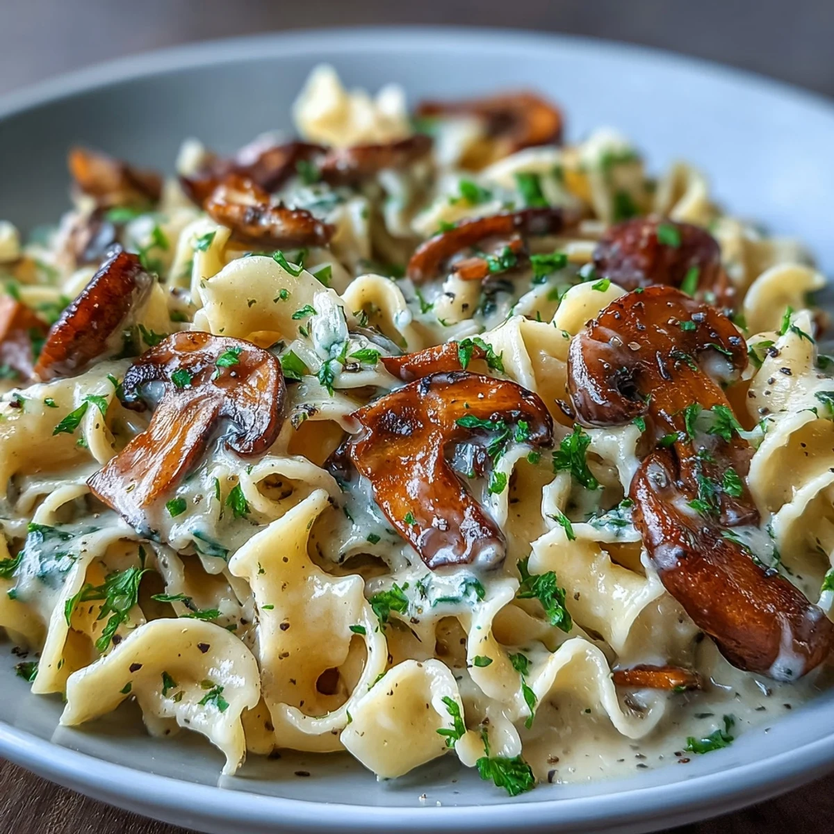 Creamy Mushroom Stroganoff twirls in wide egg noodles, coated in a silky, rich sauce topped with fresh parsley and black pepper.  