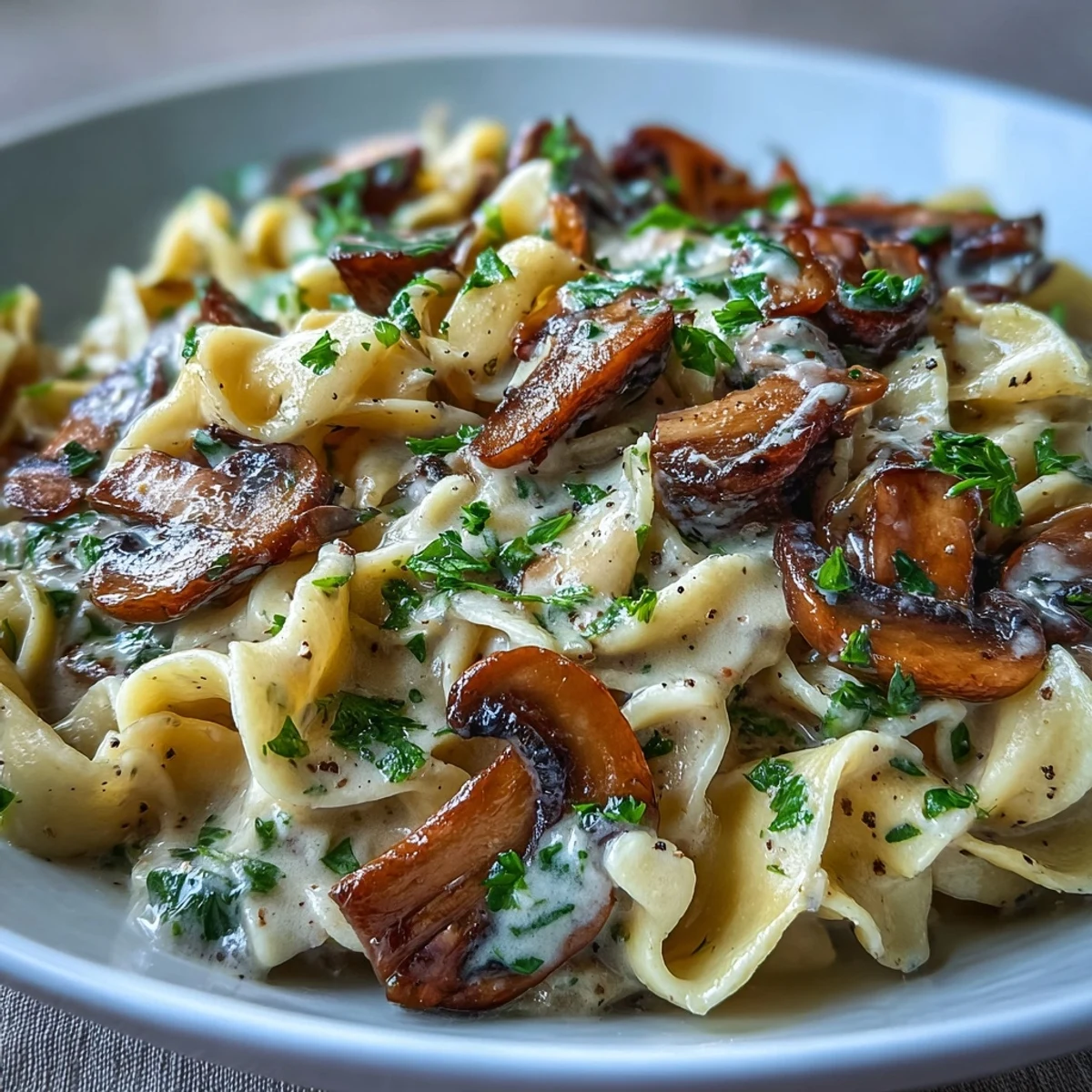 Hearty Creamy Mushroom Stroganoff combines tender noodles, savory mushrooms, and a luscious, creamy sauce garnished with fresh herbs.