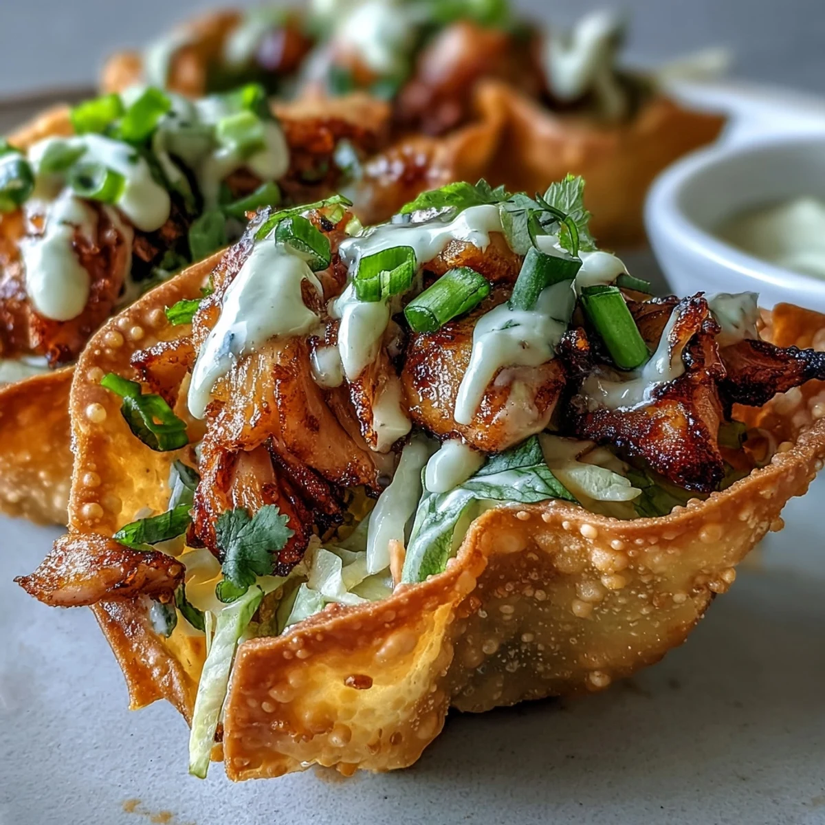 Golden-brown crispy wonton shells filled with ginger-spiced chicken, crunchy red cabbage slaw, and creamy sriracha mayo.
