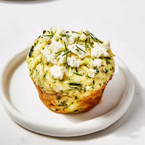 A close-up of fluffy Zucchini and Feta Muffins, revealing the delicious feta and zucchini filling.