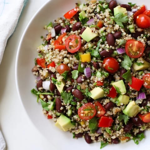 A close-up of refreshing quinoa and black bean salad with lime, showing fresh ingredients.