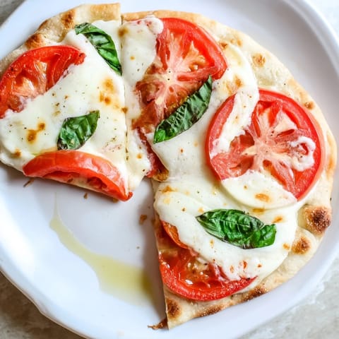 Golden-crusted edges on a baked Quick Margherita Naan Pizza, ideal for a quick, tasty vegetarian dinner.