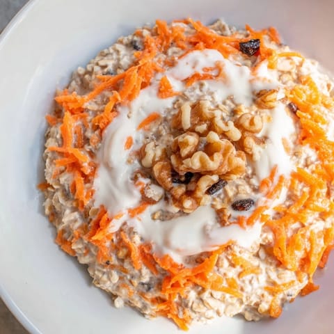 Creamy Carrot Cake Overnight Oats with grated carrots, warm spices, and a swirl of yogurt.