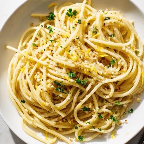Golden, glistening Garlic Butter Noodles served with fresh parsley, offering a simple comfort meal.