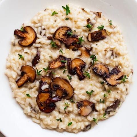 Steaming Roasted Mushroom Risotto served in a rustic bowl, topped with golden roasted mushrooms and parsley.