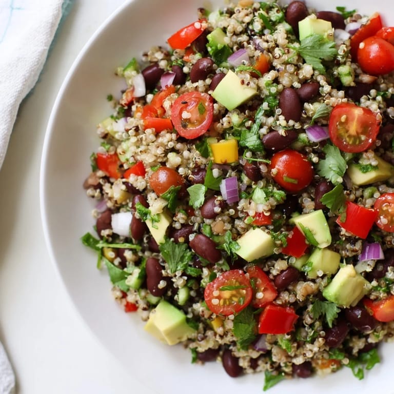 A close-up of refreshing quinoa and black bean salad with lime, showing fresh ingredients.