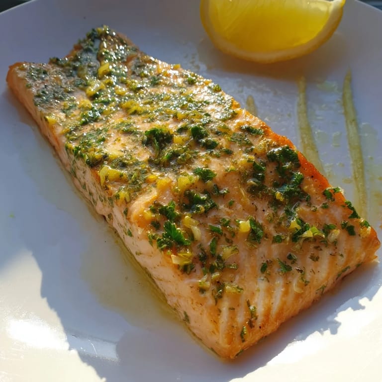 This photo shows a close-up of the finished Easy Herb-Crusted Salmon with Asparagus, ready to enjoy with lemon wedges.