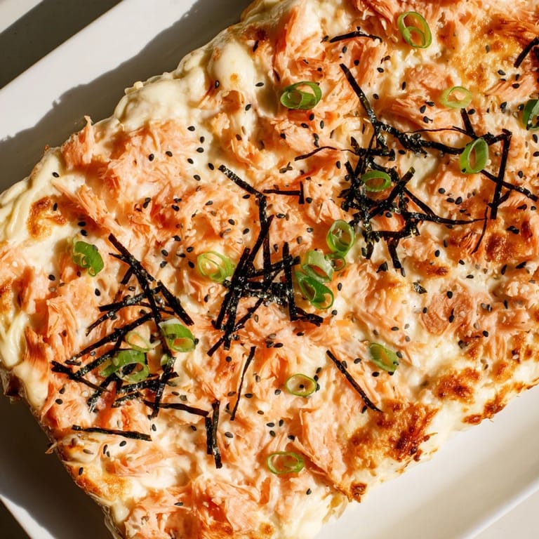 This Creamy Salmon Sushi Bake features flaked salmon and creamy sauce over sushi rice, irresistible textures.