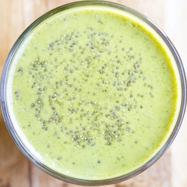 Two servings of refreshing Spinach-Hidden Smoothie, topped with a sprinkle of chia seeds, ready to sip on a sunny kitchen counter.