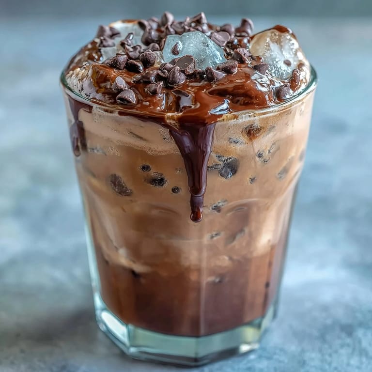 Velvety chocolate cream floats atop chilled cold brew coffee, creating a decadent and refreshing layered beverage.