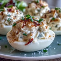 Crab Cake Deviled Eggs with Old Bay Seasoning: creamy crab filling in halved eggs, dusted with zesty Old Bay for a seafood appetizer.  